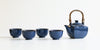 Side view of a dark blue ceramic tea set, with four cups on the left and a pot on the right.