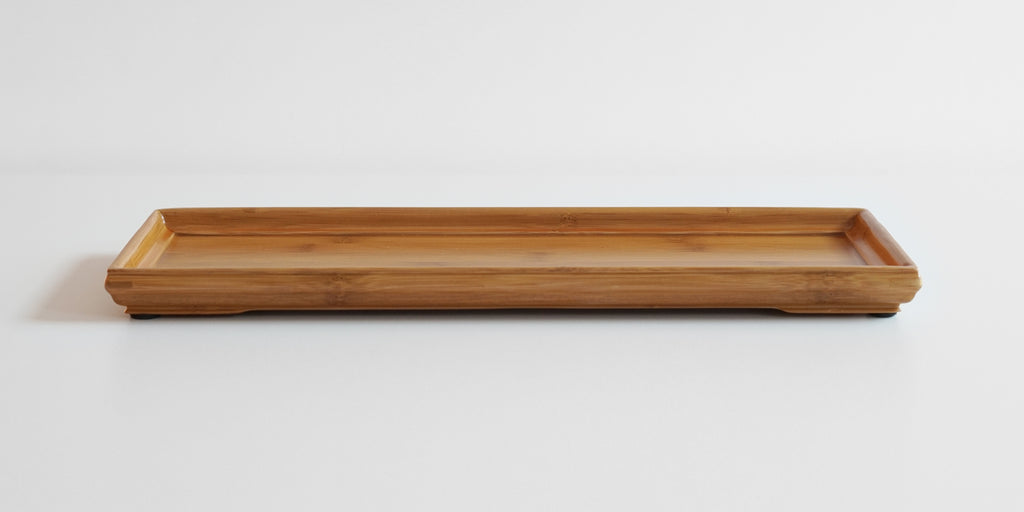 A rectangular bamboo service tray with a slightly raised edge, displayed on a plain background.