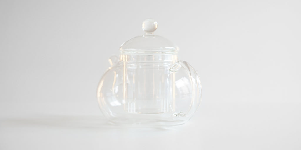 Rear view of a glass teapot, with the infuser hanging inside.