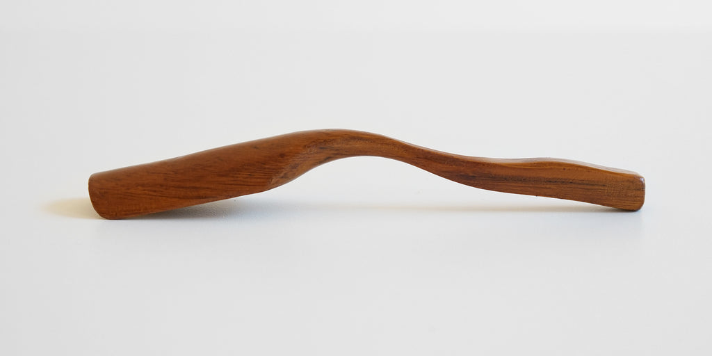 Side view of a cherrywood scoop, darker wood grain running along the handle.