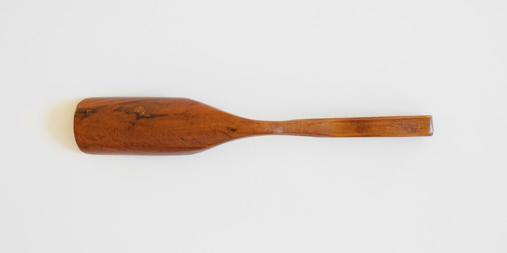 Bottom view of a cherrywood tea scoop, with dark grain patterns on the scoop.