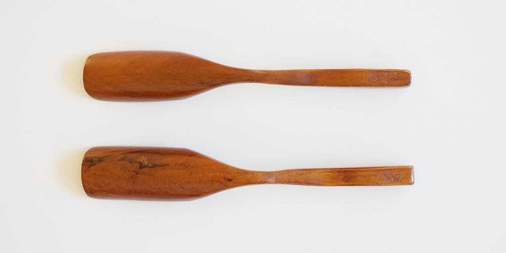 The bottoms of two cherrywood scoops, showcasing natural grain texture.