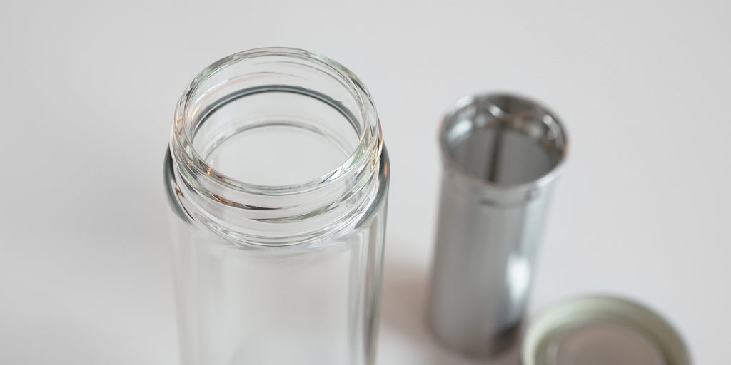 Close up of the lip of the glass thermos, threaded to match with the lid. It's double-walled to insulate heat and has a small lip for the strainer basket to snap onto.