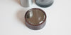 Top down view of the top of the lid. It has subtle knurling around the outside to make it easier to grip, and a mirror on top.