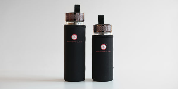 Two fully assembled thermoses, showing the Red Blossom Tea Company logo in red on the black cozys. The one on the left is large, and the one on the right is slightly shorter.