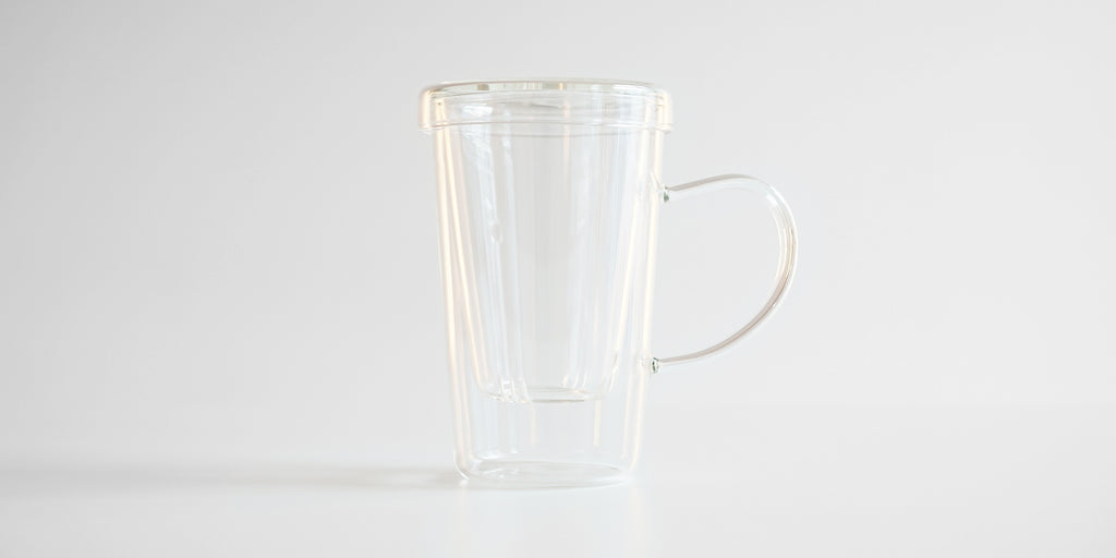 Side view of the glass infuser cup. The infuser is in the cup, and the lid covers it.