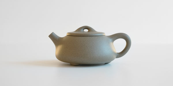 Side view of a gray duanni yixing teapot, showing its somewhat rectangular shape.
