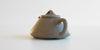 Rear view of a gray duanni yixing teapot, highlight the slightly angular handle.
