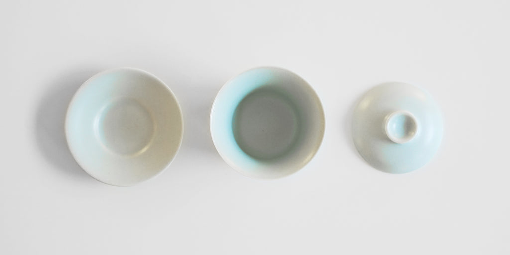 Top down view of each piece of a blue-green celadon gaiwan