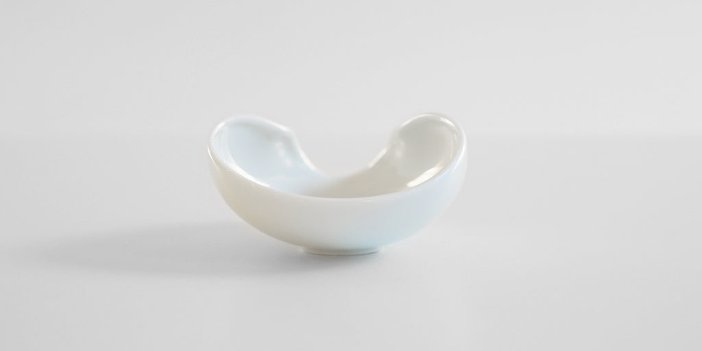 Back view of a white ceramic tea dish.