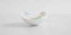 Back view of a white ceramic tea dish.