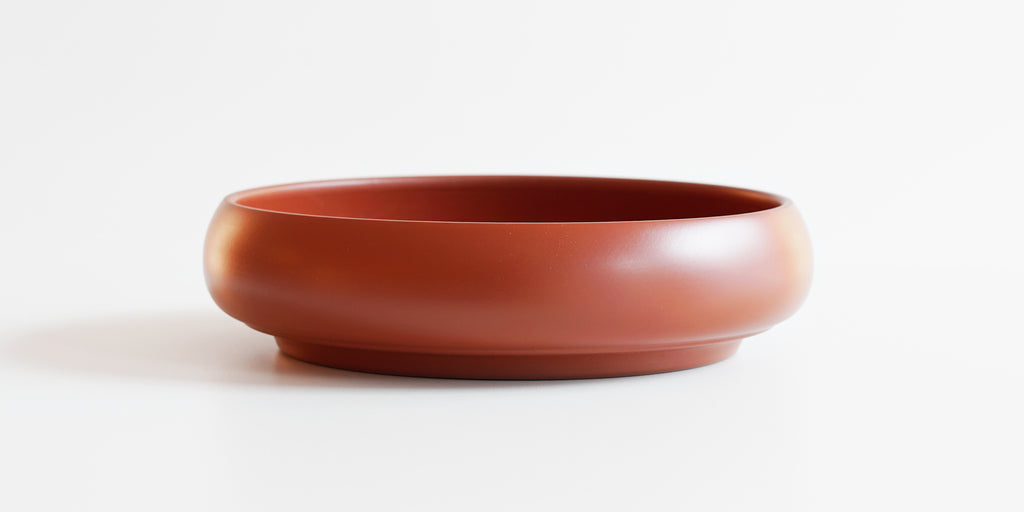 Side-view of a terracotta-colored tea tray.