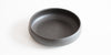A round black tea tray on a blank background.
