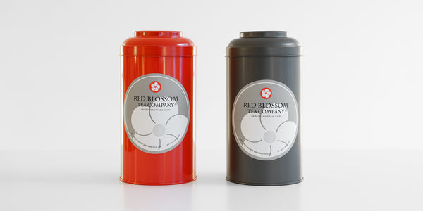 Two canisters, one red one gray, each with a Red Blossom Tea Company label.