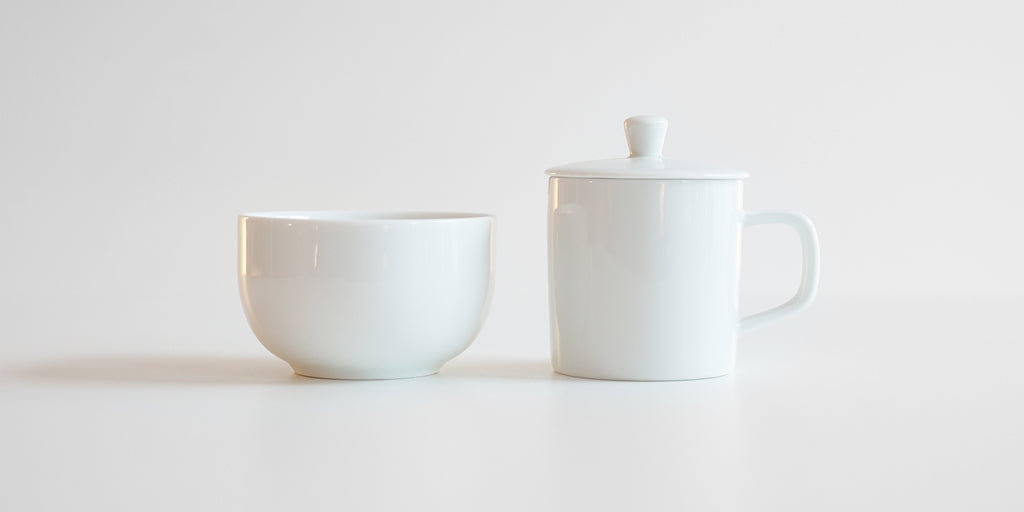 Side view of a competition brewing set. A small white bowl is on the left, and the brewing vessel, similar to a teapot but without a spout, is on the right.