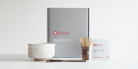 A silver box with a label reading “Matcha Starter Kit”. In front of the box are all the contents of the box.