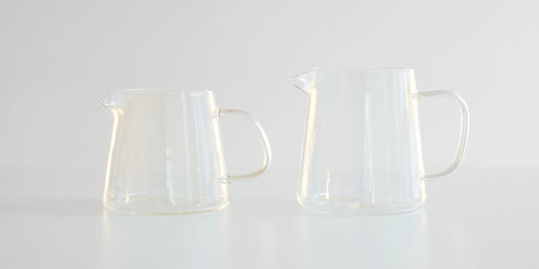 Two empty glass servers side by side. Smaller one on the left, larger on the right.