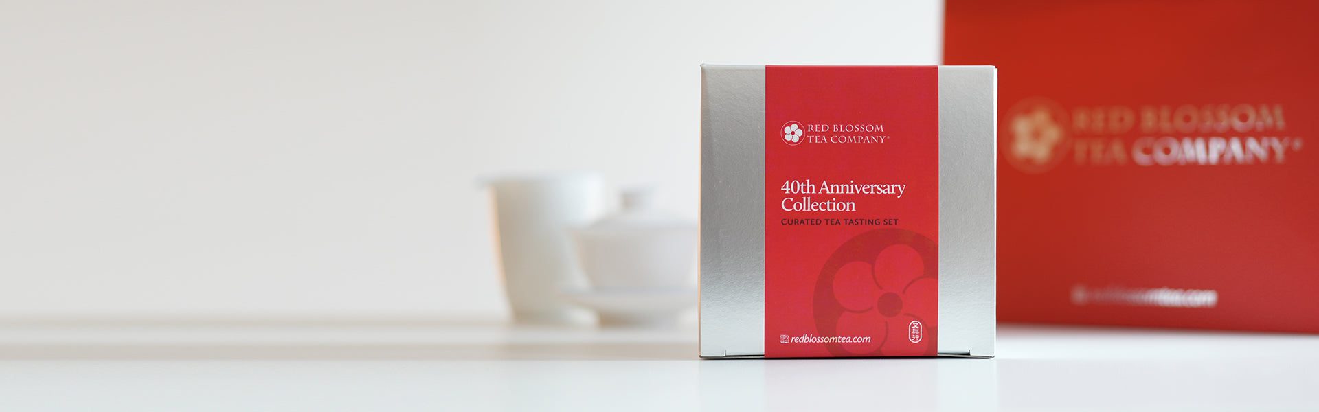 A silver box with a red label reading "40th Anniversary Collection", with a set of brewing equipment and a red branded gift bag in the background.