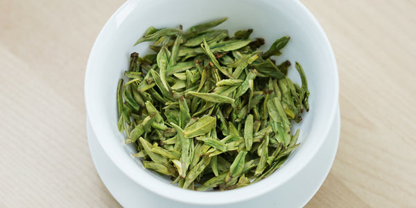 A top-down photo of brewed green tea leaves in a gaiwan.