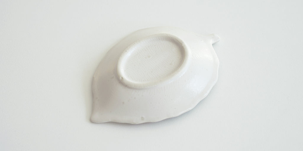 The bottom of a leaf trivet, white with a matte finish.