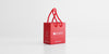 A small red bag with Red Blossom Tea Company's logo on it in reflective silver.