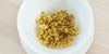 A top-down photo of brewed osmanthus flowers in a gaiwan.
