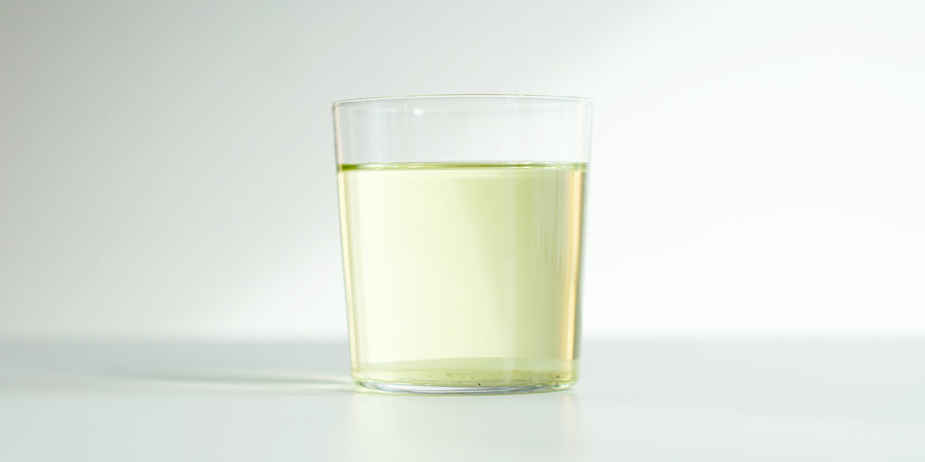 A glass cup filled with brewed osmanthus flower tea.