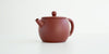 Front view of a terracotta-colored yixing pot highlighting the narrow spout.