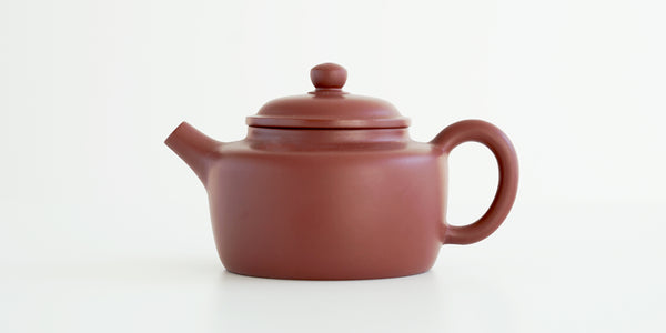 Side view of a terracotta-colored yixing pot, highlighting the rectangular shape.