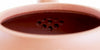 Rear view of the inside of a terracotta-colored yixing pot, showcasing the built-in filter made by punching small holes in the clay.