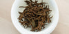 A top-down photo of brewed black tea leaves in a gaiwan.