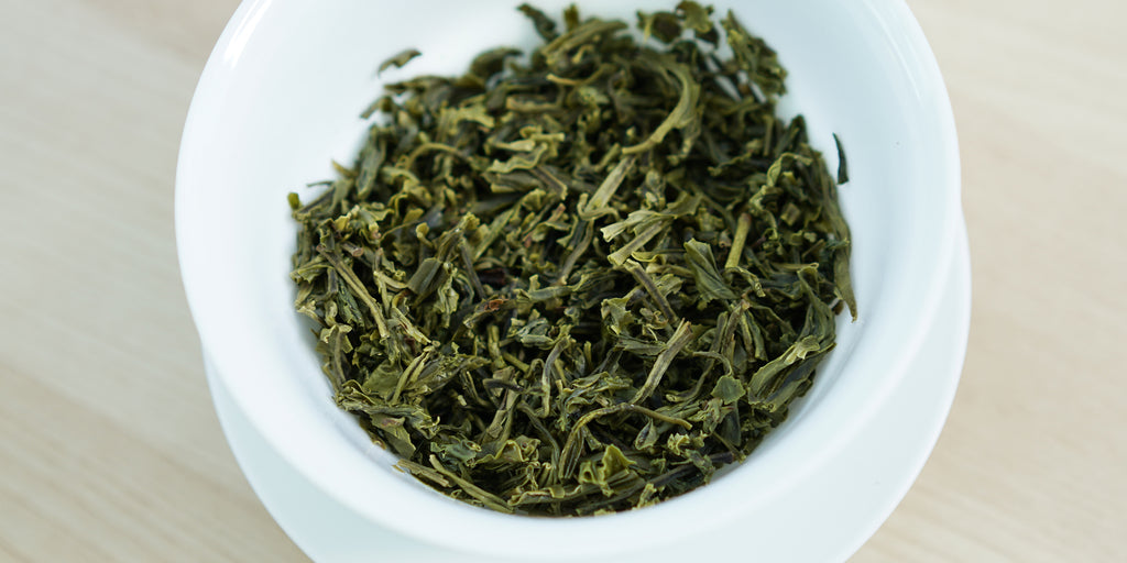 A top-down photo of brewed green tea leaves in a gaiwan.
