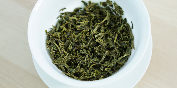 A top-down photo of brewed green tea leaves in a gaiwan.