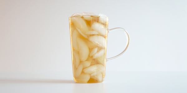 A glass cup filled with ice and Phoenix oolong tea on a white background.