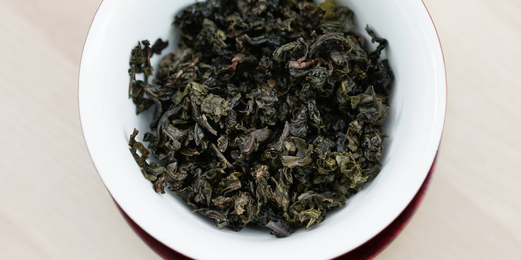 A top-down photo of brewed Tieguanyin tea leaves in a gaiwan.