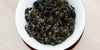 A top-down photo of brewed Tieguanyin tea leaves in a gaiwan.