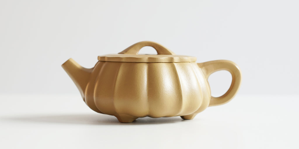 Side view of a terracotta-colored yixing pot, highlighting the gourd-likes shape.