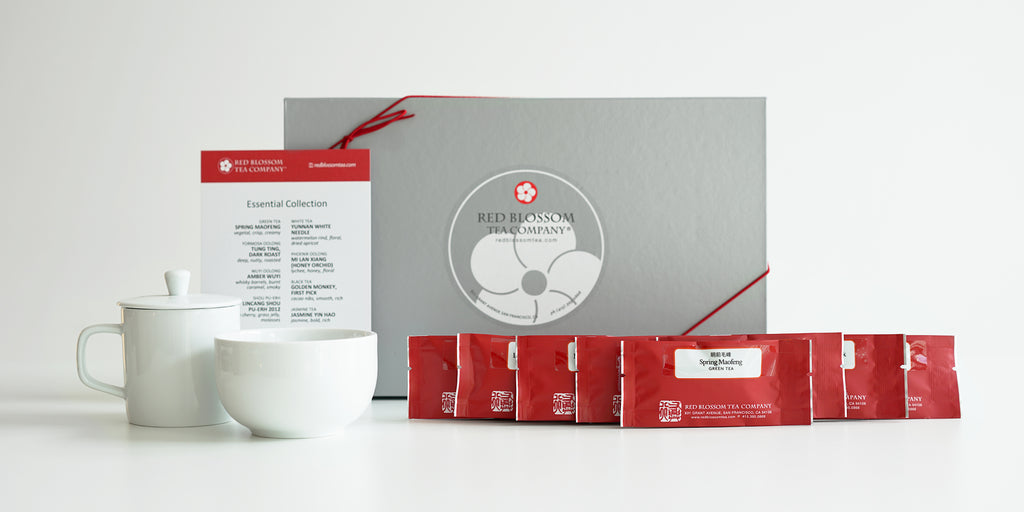 A silver box with a Red Blossom Tea Company label. In front of the box are all the contents of the box.