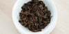 A top-down photo of brewed black tea leaves in a gaiwan.