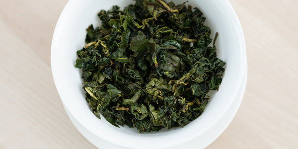 A top-down photo of brewed Formosa oolong tea leaves in a gaiwan.