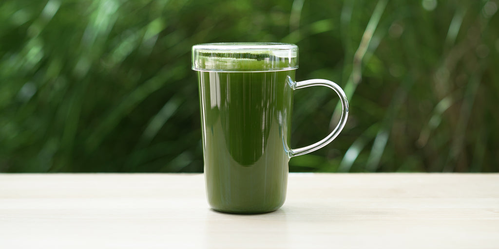 A glass cup full of brewed matcha