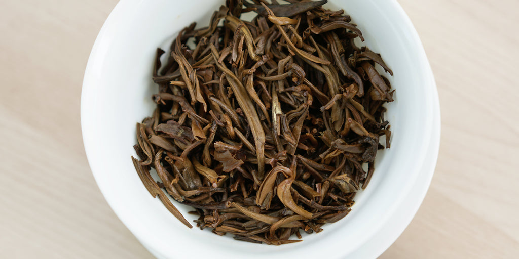 A top-down photo of brewed black tea leaves in a gaiwan.
