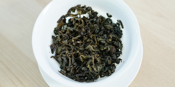 A top-down photo of brewed green tea leaves in a gaiwan.