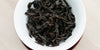 A top-down photo of brewed Wuyi oolong tea leaves in a gaiwan.