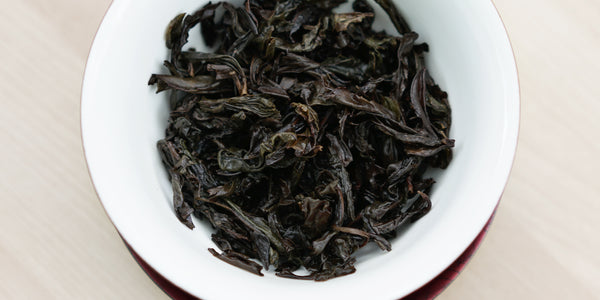A top-down photo of brewed Wuyi oolong tea leaves in a gaiwan.