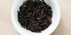 A top-down photo of brewed pu-erh tea leaves in a gaiwan.