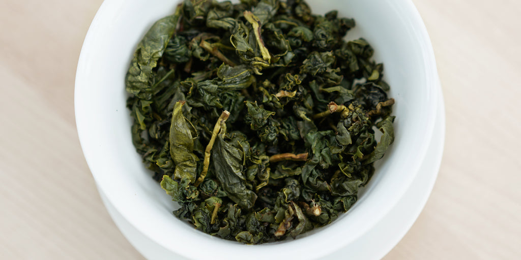 A top-down photo of brewed Formosa oolong tea leaves in a gaiwan.