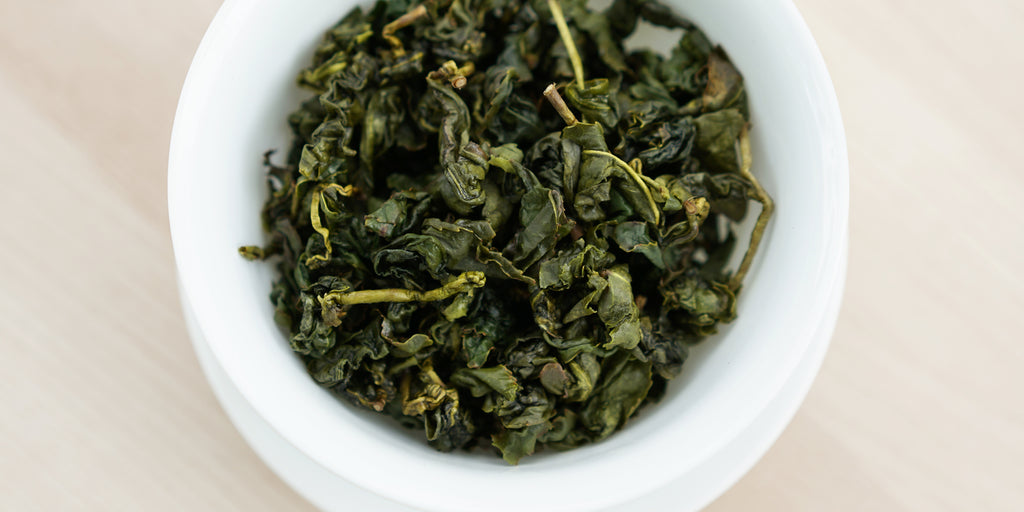 A top-down photo of brewed Formosa oolong tea leaves in a gaiwan.