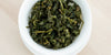 A top-down photo of brewed Formosa oolong tea leaves in a gaiwan.
