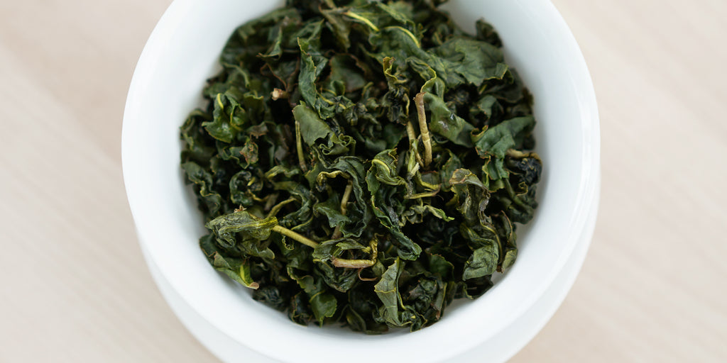 A top-down photo of brewed Formosa oolong tea leaves in a gaiwan.